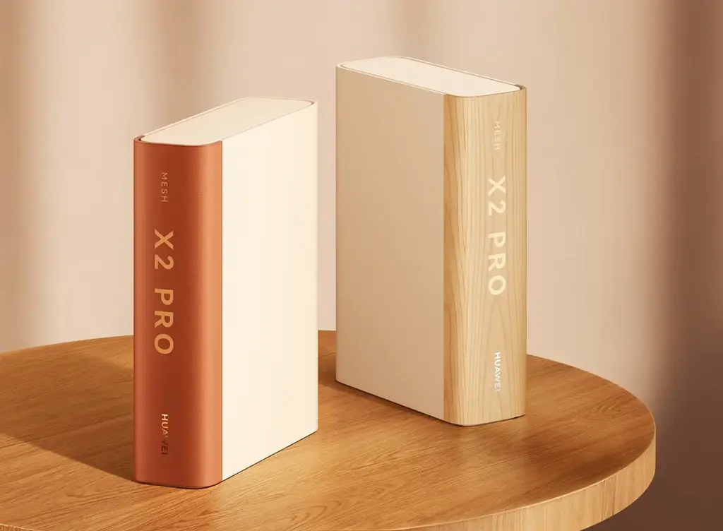 Два роутера Huawei Router X2 Pro, замаскированные под книги с магнитными корешками, стоят на деревянном столе.